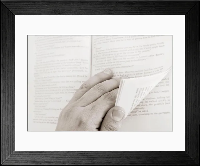 Framed Print : Close-up of hands turning the pages of an open book Framed Print : Close-up of hands turning the pages of an open book
