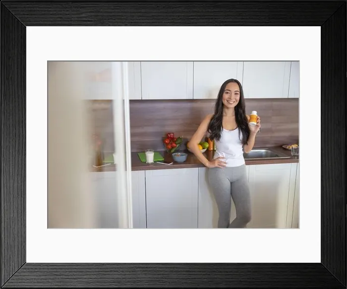 Framed Print : Woman in leggings standing in the kitchen Framed Print : Woman in leggings standing in the kitchen