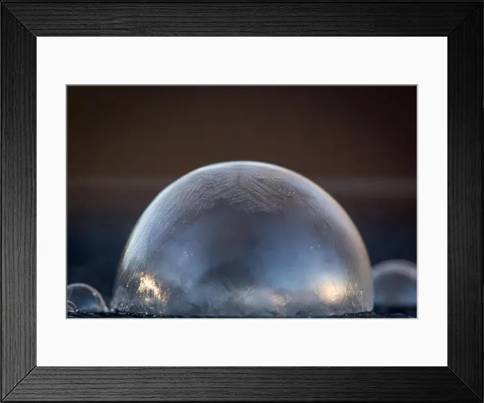 Framed Print : Icy, frozen, soap bubble dome with smaller domes beside it, on blue surface with brown background Framed Print : Icy, frozen, soap bubble dome with smaller domes beside it, on blue surface with brown background