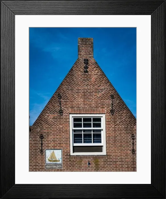Framed Print : Monnickendam, Netherlands - July 2018: Traditional brick house in the fishing town with plaque marking home of a mariner Framed Print : Monnickendam, Netherlands - July 2018: Traditional brick house in the fishing town with plaque marking home of a mariner