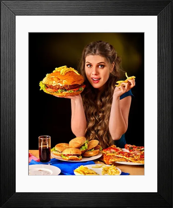 Framed Print : Woman eating french fries and hamburger on table Framed Print : Woman eating french fries and hamburger on table