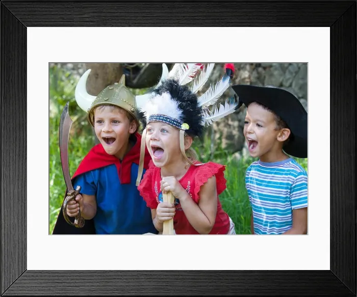 Framed Print : Three children wearing fancy dress costumes, playing in park