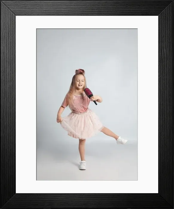 Framed Print : Cute little girl with hairbrush singing on light grey background