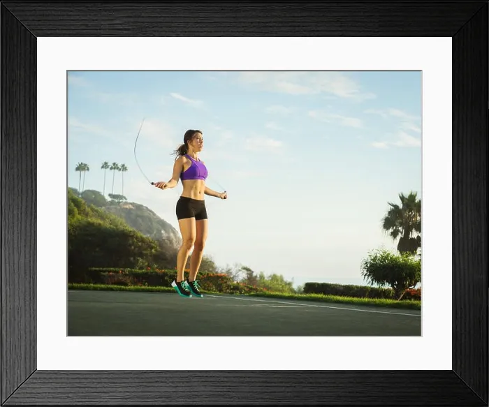 Framed Print : Young woman jumping rope in park Framed Print : Young woman jumping rope in park