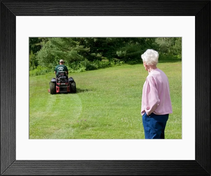 Framed Print : Lawn care service mowing elderly woman's lawn while she watches Framed Print : Lawn care service mowing elderly woman's lawn while she watches