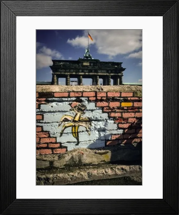 Framed Print : Grafitti of a banana at a section of the Berlin Wall in front of the famous Brandenburg Gate in spring of 1990 Framed Print : Grafitti of a banana at a section of the Berlin Wall in front of the famous Brandenburg Gate in spring of 1990