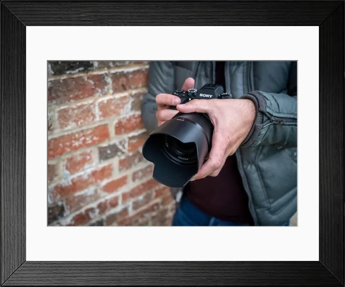 Framed Print : Close up of a male photographer holding a Sony Alpha 9 mirrorless camera Framed Print : Close up of a male photographer holding a Sony Alpha 9 mirrorless camera