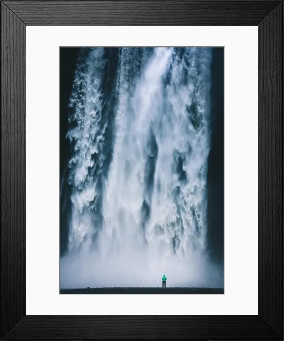 Framed Print : Vertical panorama view of hiker in colorful rain jacket standing in front of gigantic Skogafoss waterfall Framed Print : Vertical panorama view of hiker in colorful rain jacket standing in front of gigantic Skogafoss waterfall