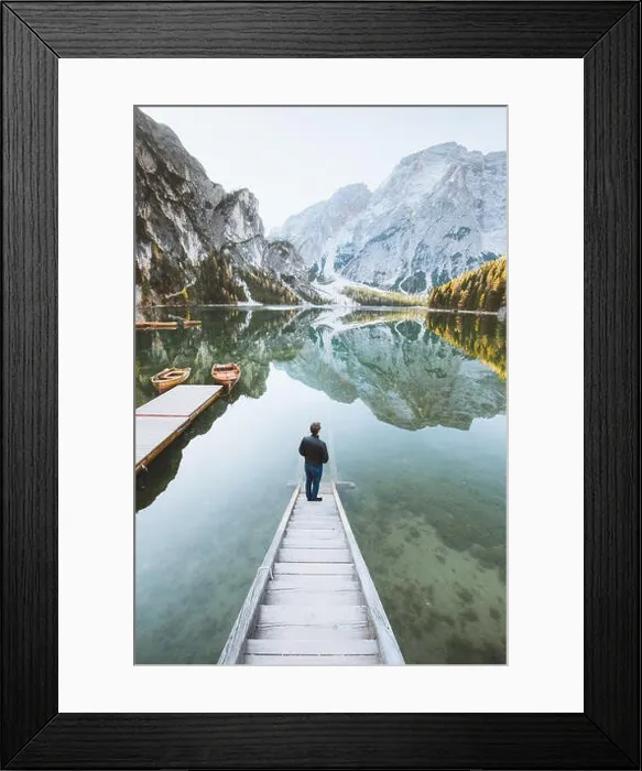 Framed Print : Beautiful view of a young man standing on wooden stairs watching the sunrise at famous Lago di Braies the Dolomites Framed Print : Beautiful view of a young man standing on wooden stairs watching the sunrise at famous Lago di Braies the Dolomites