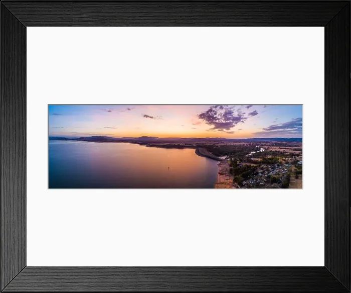 Framed Print : Lonely boat sailing across scenic lake at vivid orange sunset - aerial panoramic landscape Framed Print : Lonely boat sailing across scenic lake at vivid orange sunset - aerial panoramic landscape