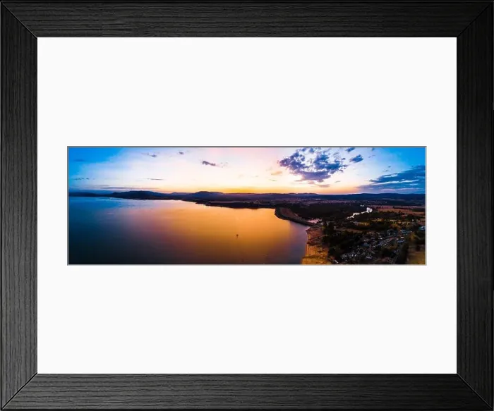 Framed Print : Lonely boat sailing across scenic lake at vivid orange sunset - aerial panorama Framed Print : Lonely boat sailing across scenic lake at vivid orange sunset - aerial panorama