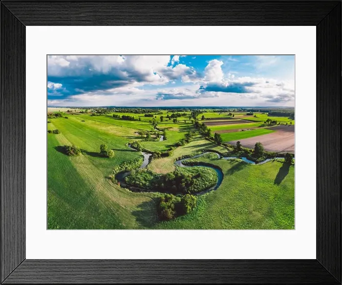 Framed Print : A winding river surrounded by green meadows Framed Print : A winding river surrounded by green meadows