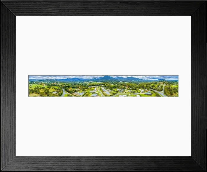 Framed Print : Wide aerial panorama of scenic countryside with houses surrounded by forest and mountains Framed Print : Wide aerial panorama of scenic countryside with houses surrounded by forest and mountains