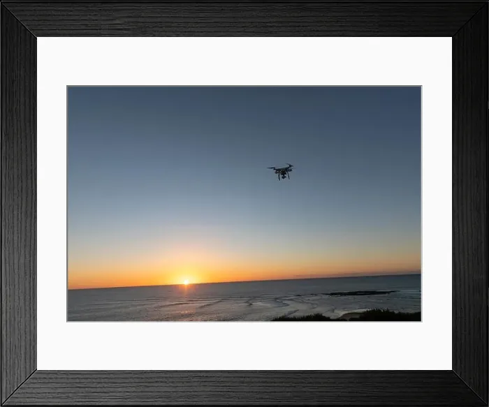 Framed Print : Professional Drone flying at Sunrise over the sea. The sky is glowing Framed Print : Professional Drone flying at Sunrise over the sea. The sky is glowing