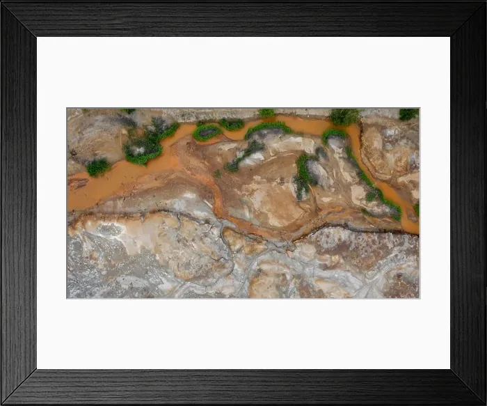 Framed Print : Aerial top down view; drone flying over a very polluted river with copper colored water; dumping of chemical waste into Framed Print : Aerial top down view; drone flying over a very polluted river with copper colored water; dumping of chemical waste into