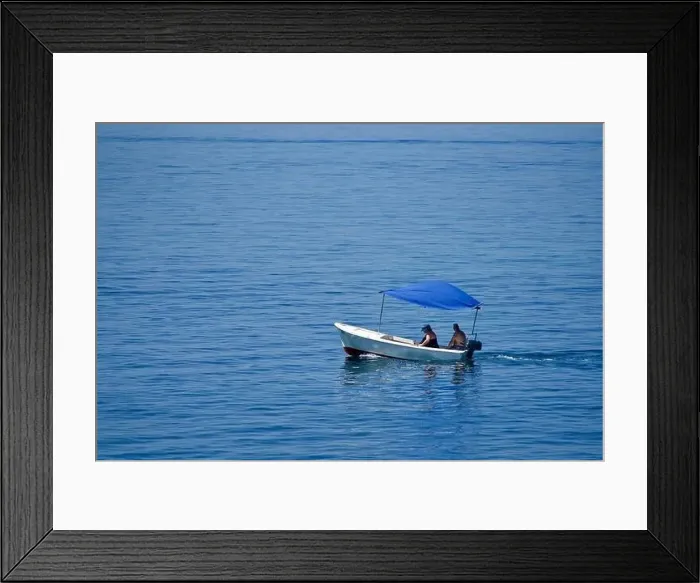 Framed Print : Couple in a little boat with a blue top on the sea