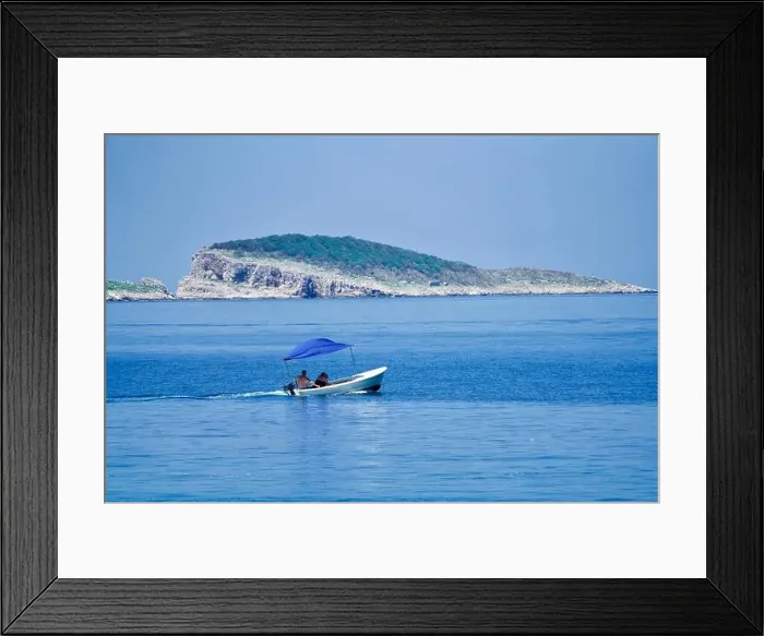 Framed Print : Little boat on the ocean in front of an island Framed Print : Little boat on the ocean in front of an island