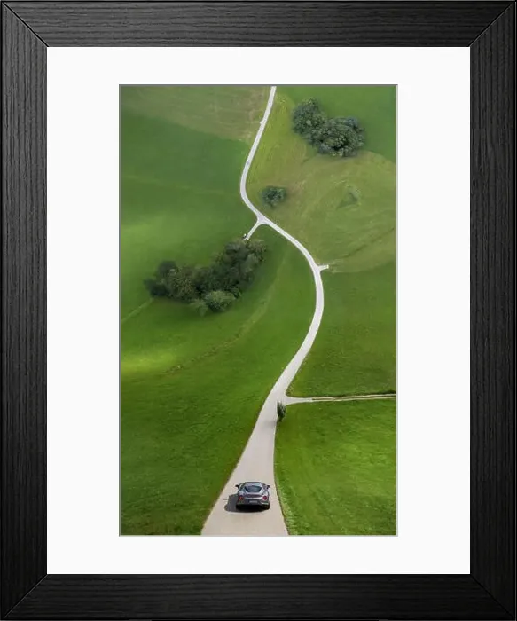 Framed Print : Droneception shot ofs curve street in countryside bending up in front of silver car Framed Print : Droneception shot ofs curve street in countryside bending up in front of silver car