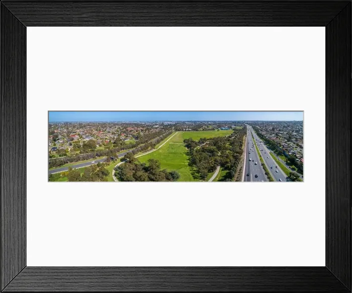 Framed Print : Aerial panoramic landscape of cars driving on highway passing through typical suburban landscape in Melbourne, Australia