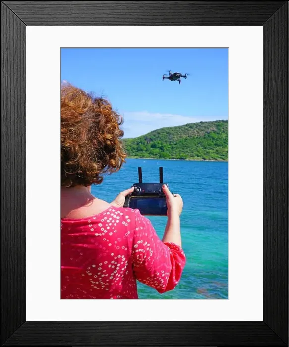 Framed Print : ST KITTS, ST KITTS AND NEVIS -21 NOV 2018- A woman taking pictures with a drone camera over the Caribbean Sea in Framed Print : ST KITTS, ST KITTS AND NEVIS -21 NOV 2018- A woman taking pictures with a drone camera over the Caribbean Sea in