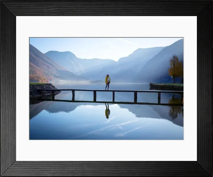 Framed Print : girl tourist in a hat and with a backpack stands on a wooden bridge on a mountain lake in the early morning Framed Print : girl tourist in a hat and with a backpack stands on a wooden bridge on a mountain lake in the early morning