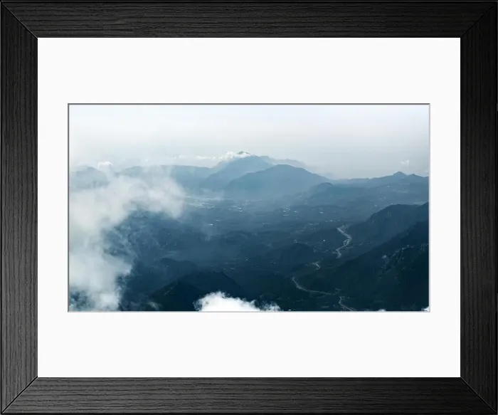 Framed Print : Panorama of beautiful silhouette mountains in blue tones with haze and clouds Framed Print : Panorama of beautiful silhouette mountains in blue tones with haze and clouds