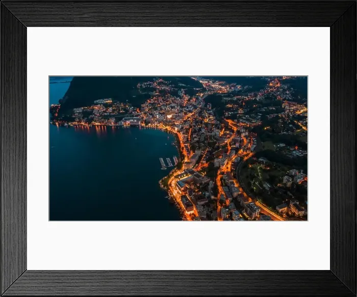 Framed Print : High angle aerial drone night shot of city street lights by lake in Lugano, Switzerland Framed Print : High angle aerial drone night shot of city street lights by lake in Lugano, Switzerland