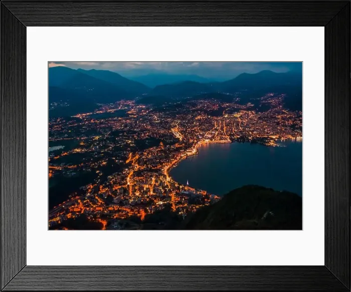 Framed Print : High angle aerial drone night shot of city street lights by lake in Lugano, Switzerland Framed Print : High angle aerial drone night shot of city street lights by lake in Lugano, Switzerland