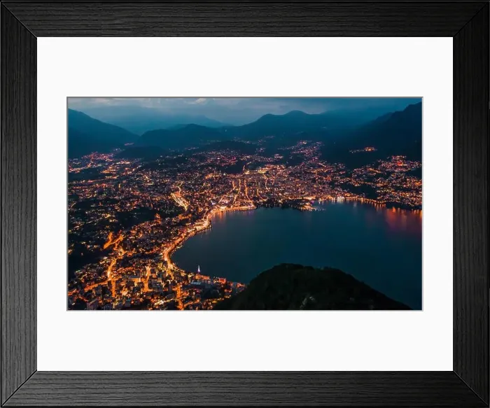 Framed Print : High angle aerial drone night shot of city street lights by lake in Lugano, Switzerland Framed Print : High angle aerial drone night shot of city street lights by lake in Lugano, Switzerland
