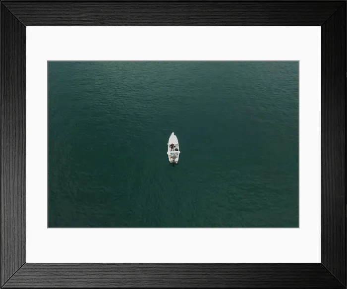 Framed Print : Malcesine, Italy - August 7, 2019: Aerial drone shot view of two men in a white boat in lake garda Framed Print : Malcesine, Italy - August 7, 2019: Aerial drone shot view of two men in a white boat in lake garda