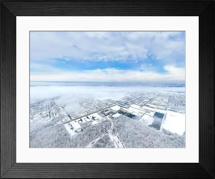 Framed Print : An aerial / drone view looking over a small city in Illinois after a snow storm with the clouds starting to clear Framed Print : An aerial / drone view looking over a small city in Illinois after a snow storm with the clouds starting to clear