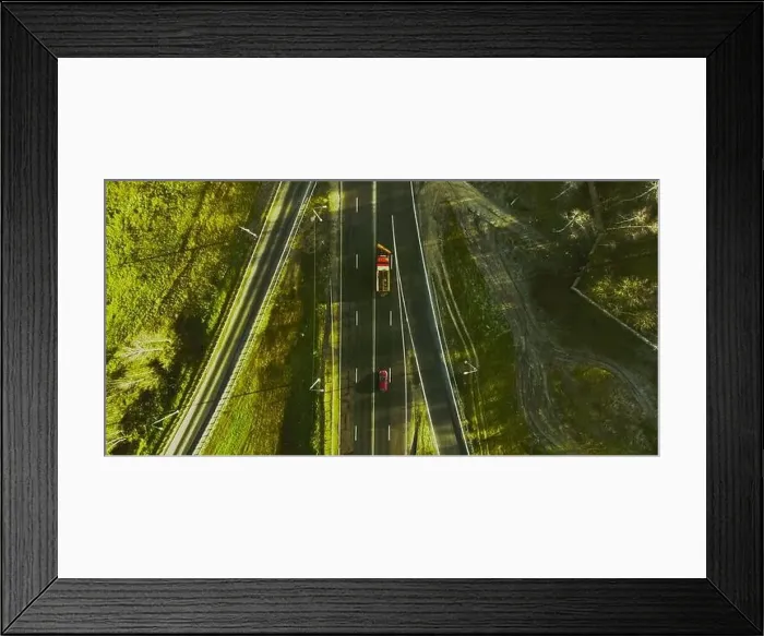 Framed Print : Drone view of moving cars on country side road with beautiful green landscape around Framed Print : Drone view of moving cars on country side road with beautiful green landscape around