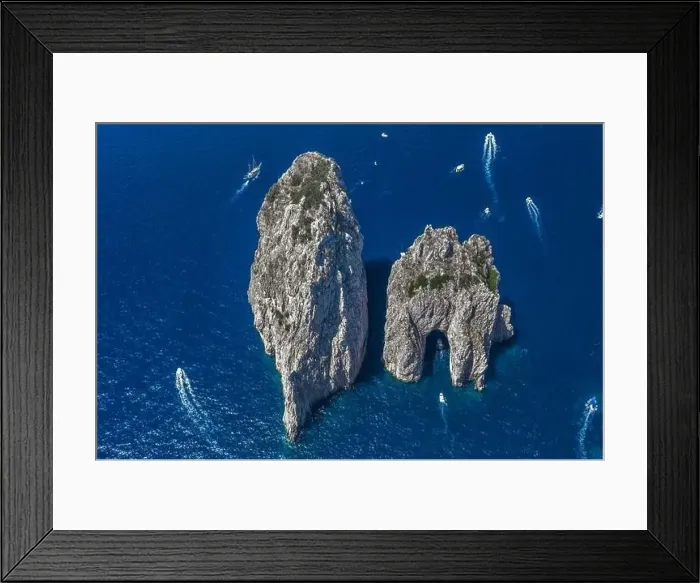 Framed Print : Aerial drone shot view of faraglioni limestone crags in summer in Tyrrhenian sea with yachts off Capri Island Framed Print : Aerial drone shot view of faraglioni limestone crags in summer in Tyrrhenian sea with yachts off Capri Island