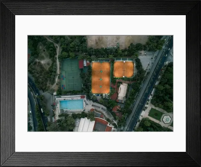 Framed Print : Aerial overhead drone shot of tennis court with lights and swimming pool at dusk in Athens Framed Print : Aerial overhead drone shot of tennis court with lights and swimming pool at dusk in Athens