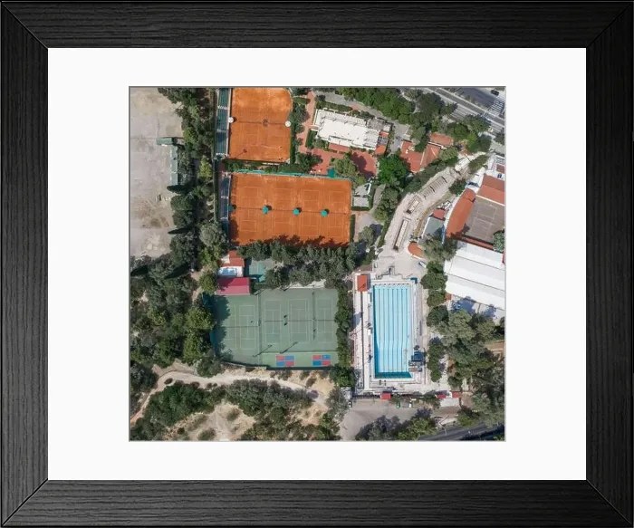 Framed Print : Aerial overhead drone shot of hard and clay tennis court besides swimming pool in Athens Framed Print : Aerial overhead drone shot of hard and clay tennis court besides swimming pool in Athens