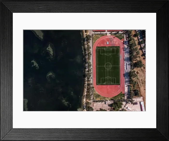 Framed Print : Aerial overhead drone shot of football field by Ionian sea in Argostolion, on Kefalonia Island Framed Print : Aerial overhead drone shot of football field by Ionian sea in Argostolion, on Kefalonia Island