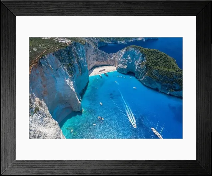 Framed Print : Aerial drone shot of Zakynthos Navagio beach with tourists with cruise ship in blue Ionnian sea Framed Print : Aerial drone shot of Zakynthos Navagio beach with tourists with cruise ship in blue Ionnian sea