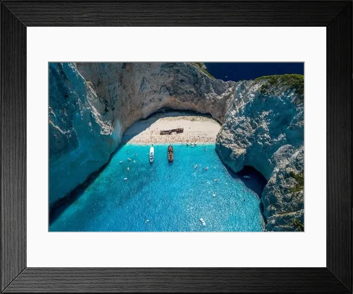 Framed Print : Aerial drone shot of Zakynthos Navagio beach with tourists with cruise ship in blue Ionnian sea Framed Print : Aerial drone shot of Zakynthos Navagio beach with tourists with cruise ship in blue Ionnian sea