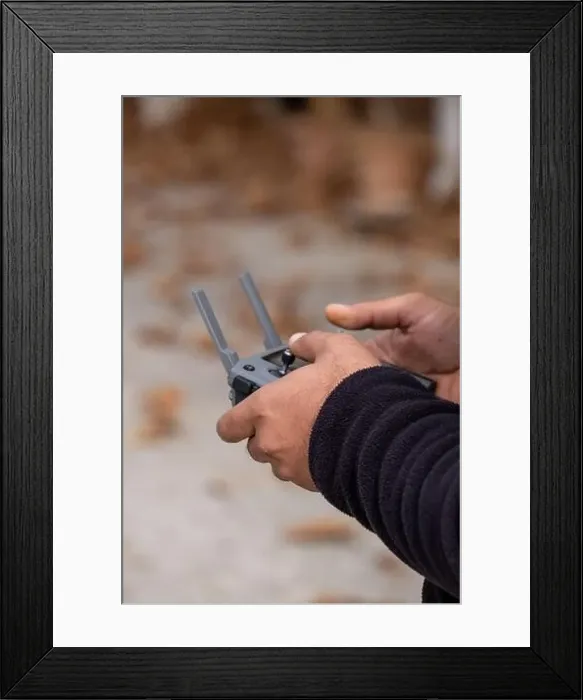 Framed Print : hand holding remote controller of flying drone Framed Print : hand holding remote controller of flying drone