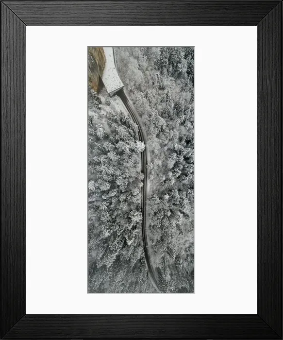 Framed Print : Aerial view of snowy forest with a road. Captured from above with a drone Framed Print : Aerial view of snowy forest with a road. Captured from above with a drone