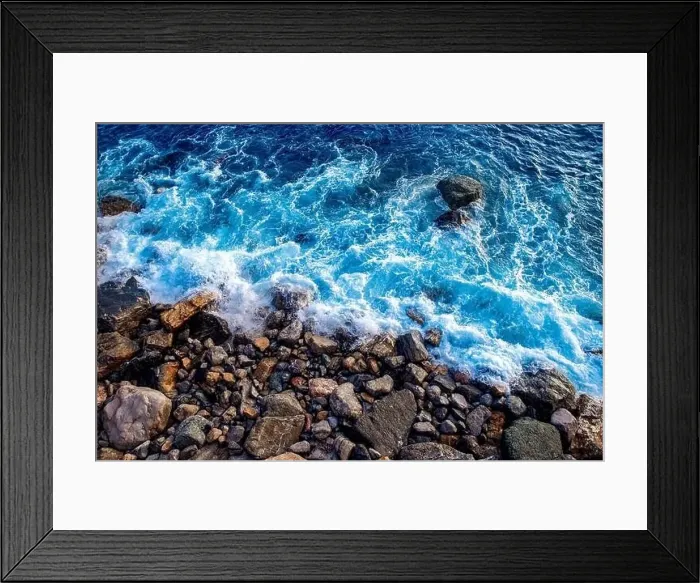 Framed Print : Top view aerial drone close up. Strong waves of blue sea wash wild rocky beach with big stones Framed Print : Top view aerial drone close up. Strong waves of blue sea wash wild rocky beach with big stones