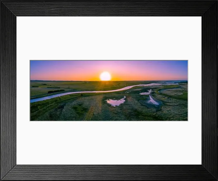 Framed Print : Scenic river flowing among meadows and pastures at sunset - wide aerial panorama Framed Print : Scenic river flowing among meadows and pastures at sunset - wide aerial panorama
