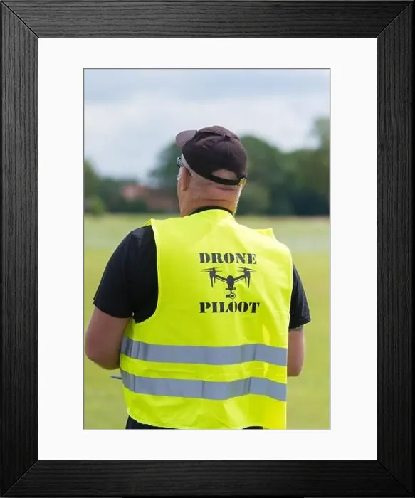 Framed Print : NIJVERDAL, NETHERLANDS - JUNE 23, 2018: Professional drone pilot controling a drone with camera Framed Print : NIJVERDAL, NETHERLANDS - JUNE 23, 2018: Professional drone pilot controling a drone with camera