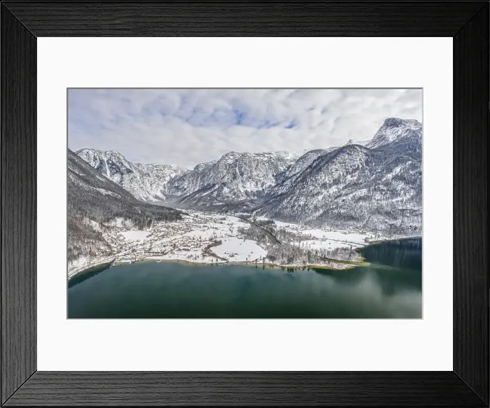 Framed Print : Aerial drone shot of Obertraun village in snow mountain valley by Hallstatt lake in Austria in winter Framed Print : Aerial drone shot of Obertraun village in snow mountain valley by Hallstatt lake in Austria in winter