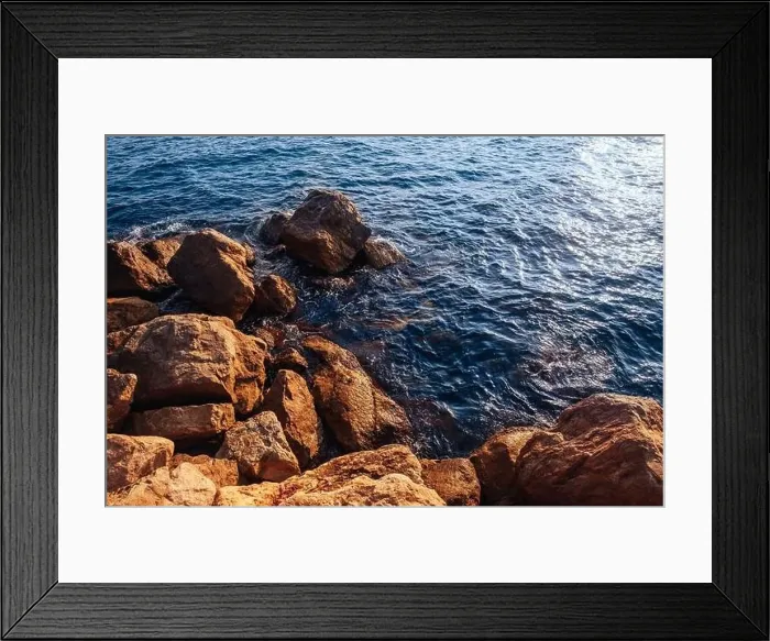 Framed Print : Stormy sea with waves and splashes breaks on sharp stones, warm day, light of sun