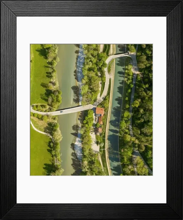 Framed Print : Top view from a drone at a driving car at a bridge over a river with a neaby forest and a house