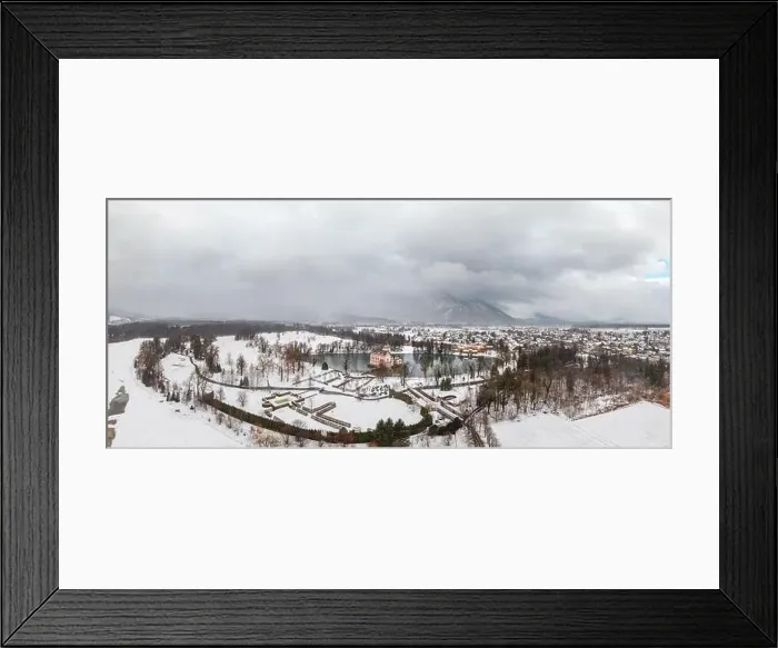 Framed Print : Panoramic aerial view of Schloss Anif castle moated in artificial pond near Salzburg outskirts in heavy snow during Framed Print : Panoramic aerial view of Schloss Anif castle moated in artificial pond near Salzburg outskirts in heavy snow during