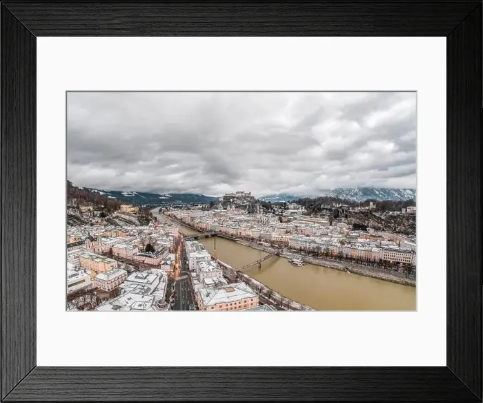 Framed Print : Aerial drone shot view of snowy Salzburg city old town by river at dusk with clouds in witner with heavy clouds Framed Print : Aerial drone shot view of snowy Salzburg city old town by river at dusk with clouds in witner with heavy clouds