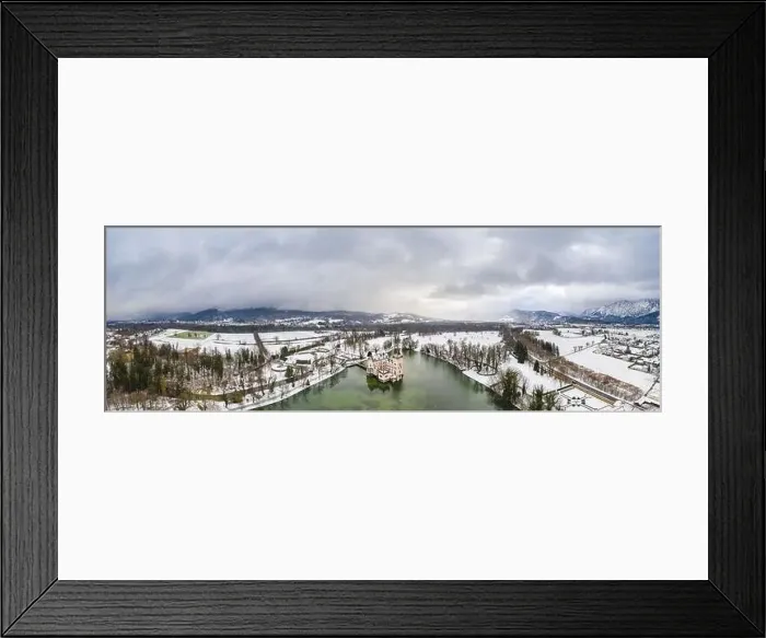 Framed Print : Panoramic aerial view of Schloss Anif castle moated in artificial pond at Salzburg outskirts in heavy snow during Framed Print : Panoramic aerial view of Schloss Anif castle moated in artificial pond at Salzburg outskirts in heavy snow during