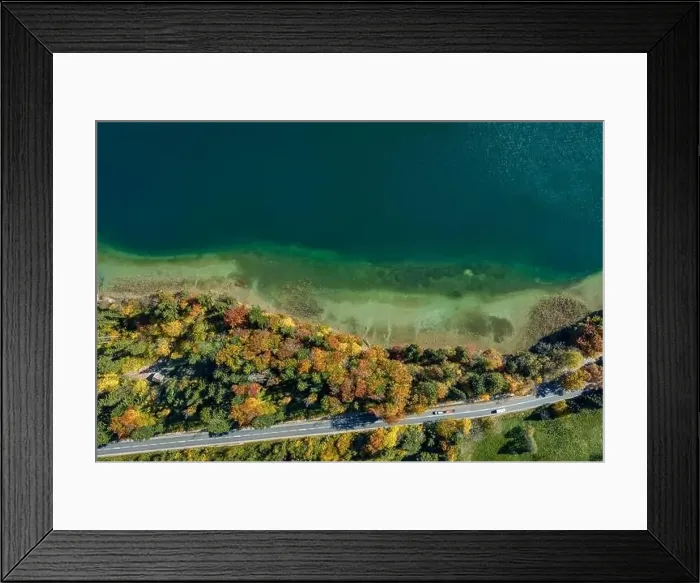 Framed Print : Top view drone shot of a lake with a colorful forest at autumn and a street in the lower section of the photo Framed Print : Top view drone shot of a lake with a colorful forest at autumn and a street in the lower section of the photo